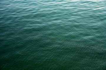 Water background texture. Sea surface in sunset light. Breezy wavy seawater. Sea water texture. Teal blue ocean view. Fresh water of lake. Relaxing natural photo wallpaper. Still water surface	