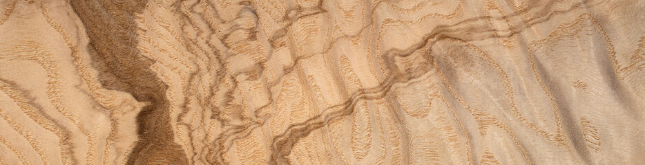 Warm golden hues of olive ash root veneer with dynamic wood grain