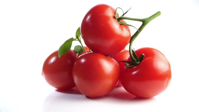 Reife rote Tomaten drehen sich auf wei&szlig;em Hintergrund isoliert