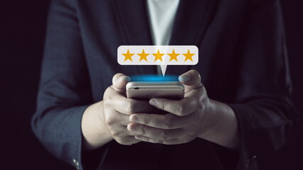 Customer Experiences Concept.Using Smartphone to Submit Five Star Review Rating for Online Satisfaction Surveys. Positive Feedback on Mobile Phone