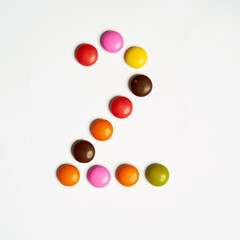 Colored chocolate coated candy alphabet on white background. 2