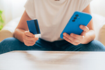 Person Holding Credit Card and Smartphone for Online Shopping