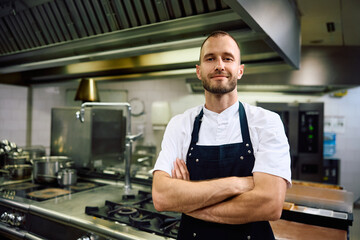 Portrait of confident cook in  kitchen in restaurant looking at camera.