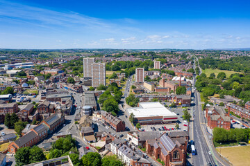 Aerial photo of the town centre of Armley in Leeds West Yorkshire on a bright sunny summers day showing apartment flats block building with the main road leading up to the main street in the village