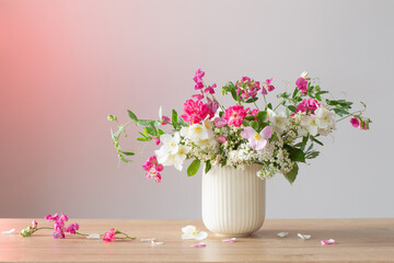 summer flowers in ceramic cup on light background