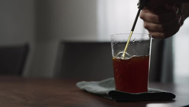 Slow motion pour nitro coffe in tumbler glass on wood table