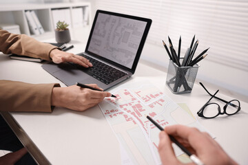 Fototapeta premium Cartographers working with cadastral maps at white table in office, closeup