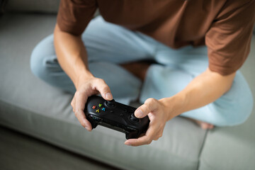 Young Asian man gamer controller video console playing holding hobby playful Online Video Game enjoyment eSport Cyber Games Internet.
