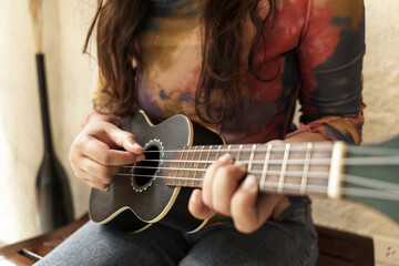 Woman playing ukulele cheerful girl learns to play at home