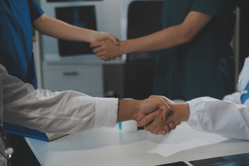 Obraz premium Doctor handshake and partnership in healthcare, medicine or trust for collaboration, unity or support.Team of medical experts shaking hands in teamwork for or success in hospital