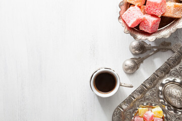 Traditional turkish coffee and turkish delight on white shabby wooden background. Top view