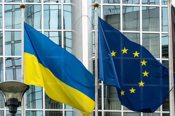 Ukraine and European union flags in front of the European Parliament buildings in Brussels. Representing the unity and support between Ukraine and the EU, especially in the context of the ongoing