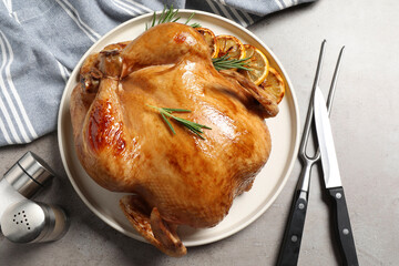 Tasty roasted chicken with rosemary and lemon served on light grey table, flat lay