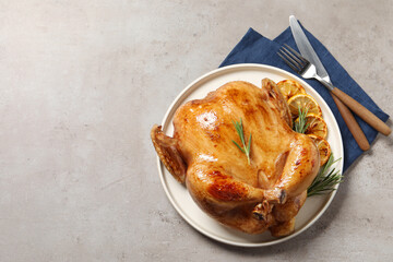 Tasty roasted chicken with rosemary and lemon served on light grey table, flat lay. Space for text