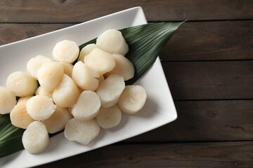 Fresh raw scallops on wooden table, top view. Space for text