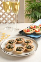 Delicious canapes with pate and capers served on white table