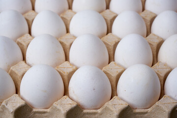 Crack open white organic egg in an egg box. Corrugated egg box.