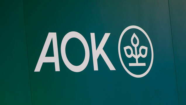 12.04.2024, FIBO-Messe f&uuml;r Fitness, Wellness und Gesundheit in K&ouml;ln. Logo am Messestand der Krankenkasse AOK.