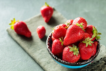 Bowl of Ripe Strawberries on Green Background with Napkin