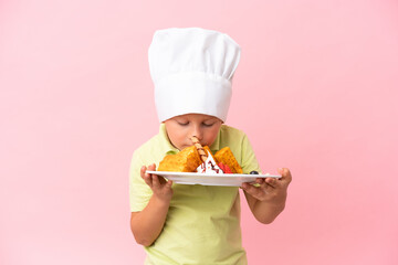 Little Russian boy holding waffles over isolated background