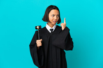 Judge over isolated blue background having doubts and thinking