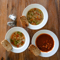 Various soups with bread on white plate