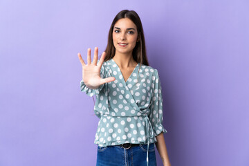 Young caucasian woman isolated on blue background counting five with fingers