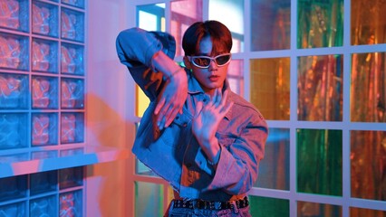 Close up of asian performer with sun glasses moving freestyle dance while looking at camera at...