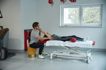 Fototapeta premium Rehabilitologist works with the shoulder joint of an elderly lady