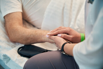 Obraz premium Nurse holding an adult patient hand in the ward
