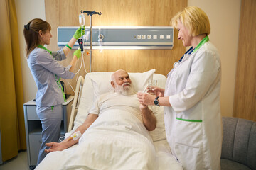 Patient takes water and pills from doctor