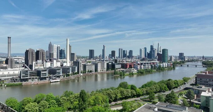 Frankfurt am Main, Hessen, Germany, May 11th, 2024: Frankfurt am Main skyline, office buildings, teh Main river and the financial district. Rising aerial view.