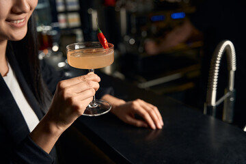 Close-up woman spending time in night club drinking alcoholic beverages