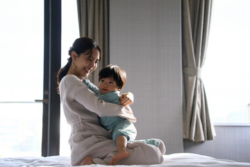 ベッドで触れ合う母と1歳10ヶ月の息子