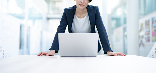 プレゼンをするスーツを着た女性