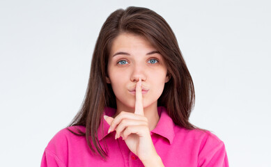 Naklejka premium Shhh sign. Young woman showing shh gesture to keep a silent. Girl in template pink t shirt keep a secret. Quiet place and silence time