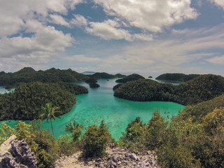 Scenic view of limestone outcrops and islands covered in vegetation in turquoise waters of  Raja Ampat regency, Wajag island