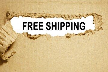 The words about free shipping are written on torn paper with a white background. Free shipping concept symbol. Copy space.