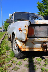 Detail of old white rusted car with front headlight