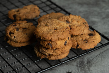 Stack of tasty chocolate cookies on gray background.
