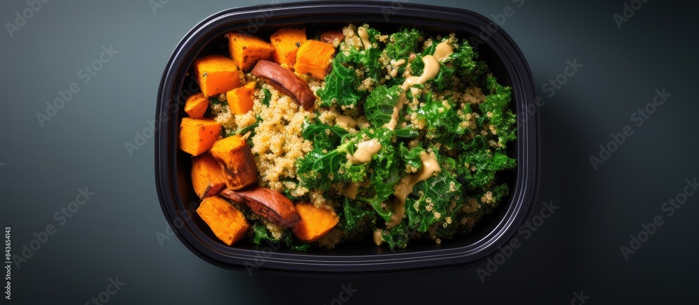 Poster an overhead view of a lunch box bowl containing sauteed kale quinoa and roasted sweet potato with sp