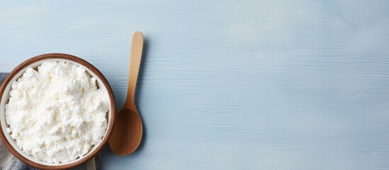 Cottage cheese in bowl with spoon for breakfast top view copy space