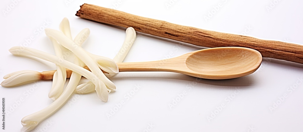 Poster copy space image of vanilla sticks and a spoon on a white background emitting a delightful aroma