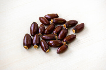 Seeds of lychee fruit isolated on light wooden background.