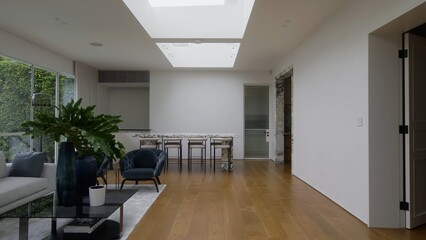 Cozy modern living room with a comfortable black chair and a plant.