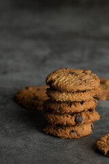Stack of tasty chocolate cookies on gray background.