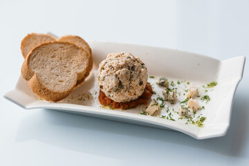 Cheese balls with herbs on a black board on a white background
