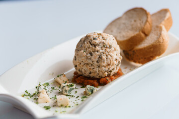Cheese balls with herbs on a black board on a white background