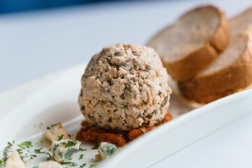 Cheese balls with herbs on a black board on a white background