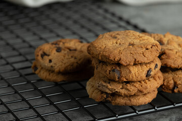 Stack of tasty chocolate cookies on gray background.